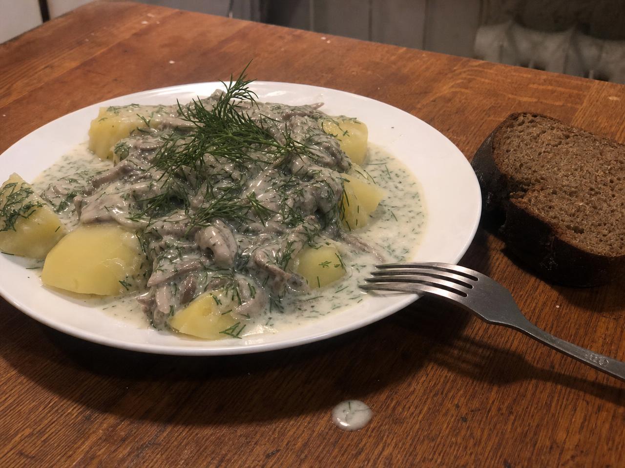 Creamy Dill Mushroom Sauce served with potatoes and bread.