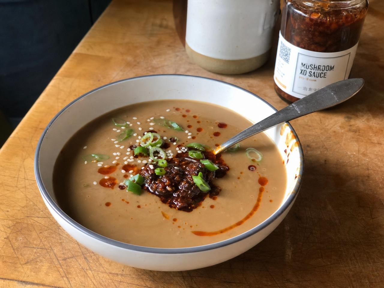 Mushroom XO Sauce in a jar next to a bowl of Miso Mushroom Soup.